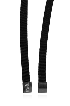 Close-up of two black elastic suspenders with silver metal clips resting on a reflective surface.