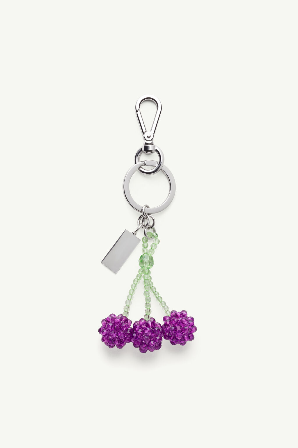 Silver keychain featuring a lobster-claw clasp, a large ring, a hanging lime-green bead stem with three purple bead flowers and a rectangular metal tag.