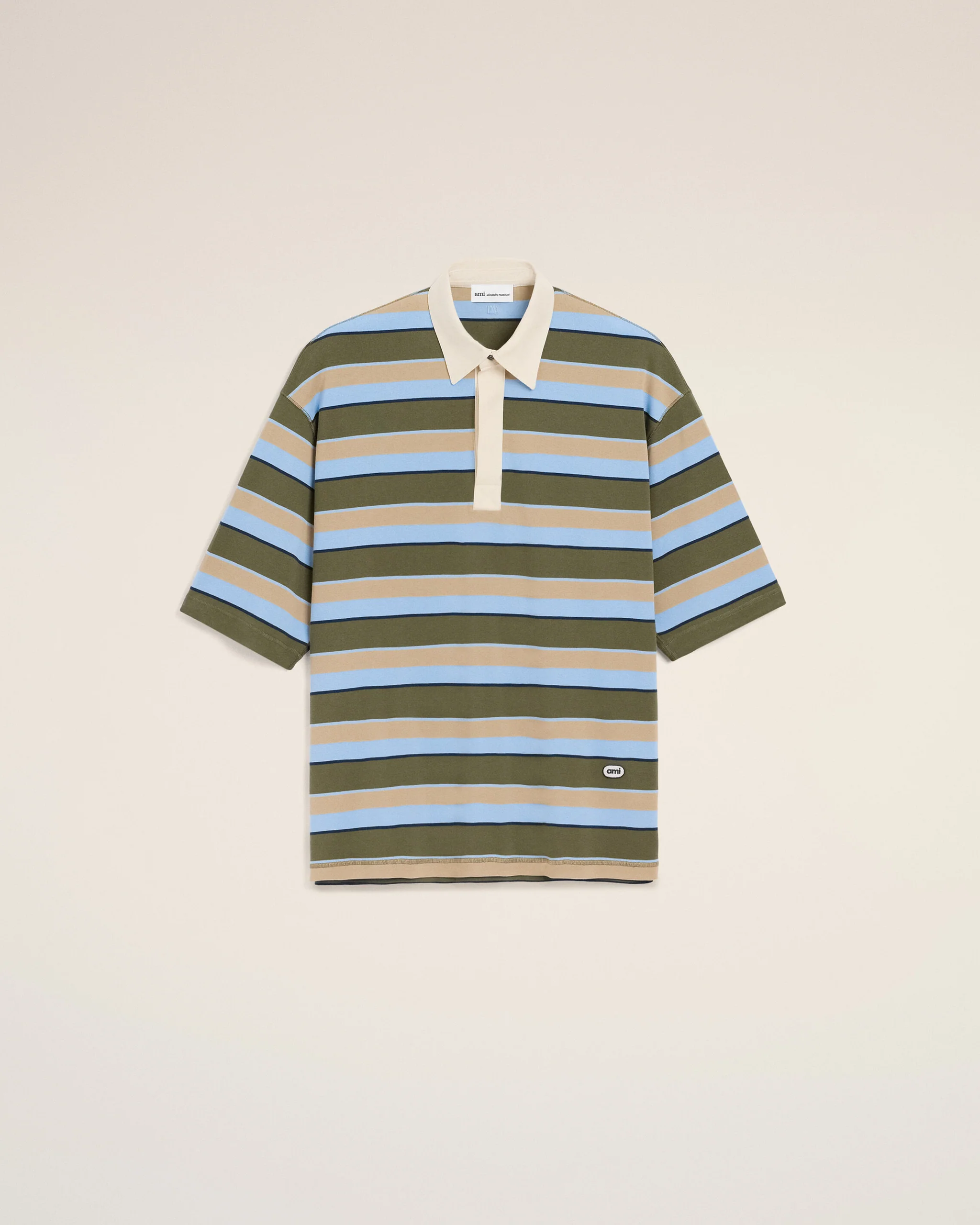 Striped polo shirt on a hanger against a light beige background; olive green, blue, and tan stripes with a cream collar and placket, centered in frame.