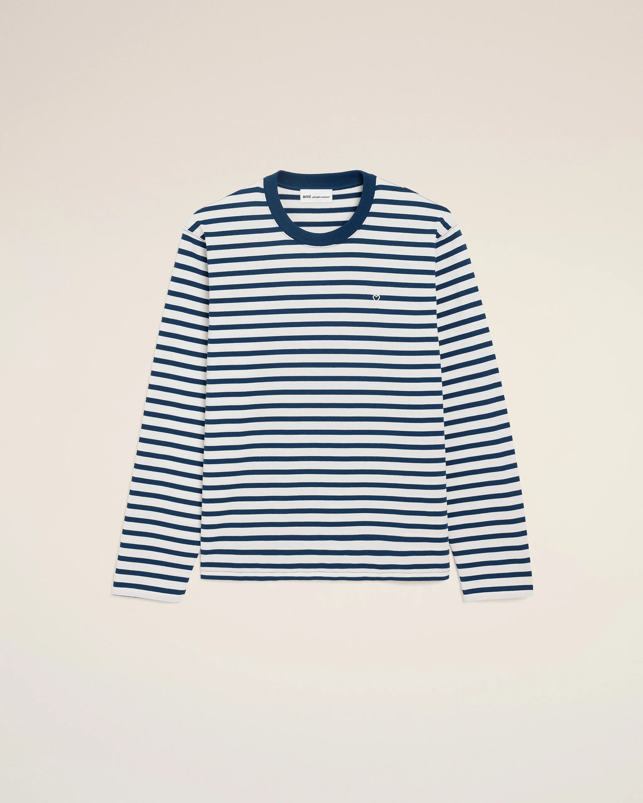 Striped navy and white long-sleeve shirt displayed against a light beige background, chest logo subtly visible.