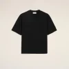 Black short-sleeve T-shirt laid flat on a beige background, front view.