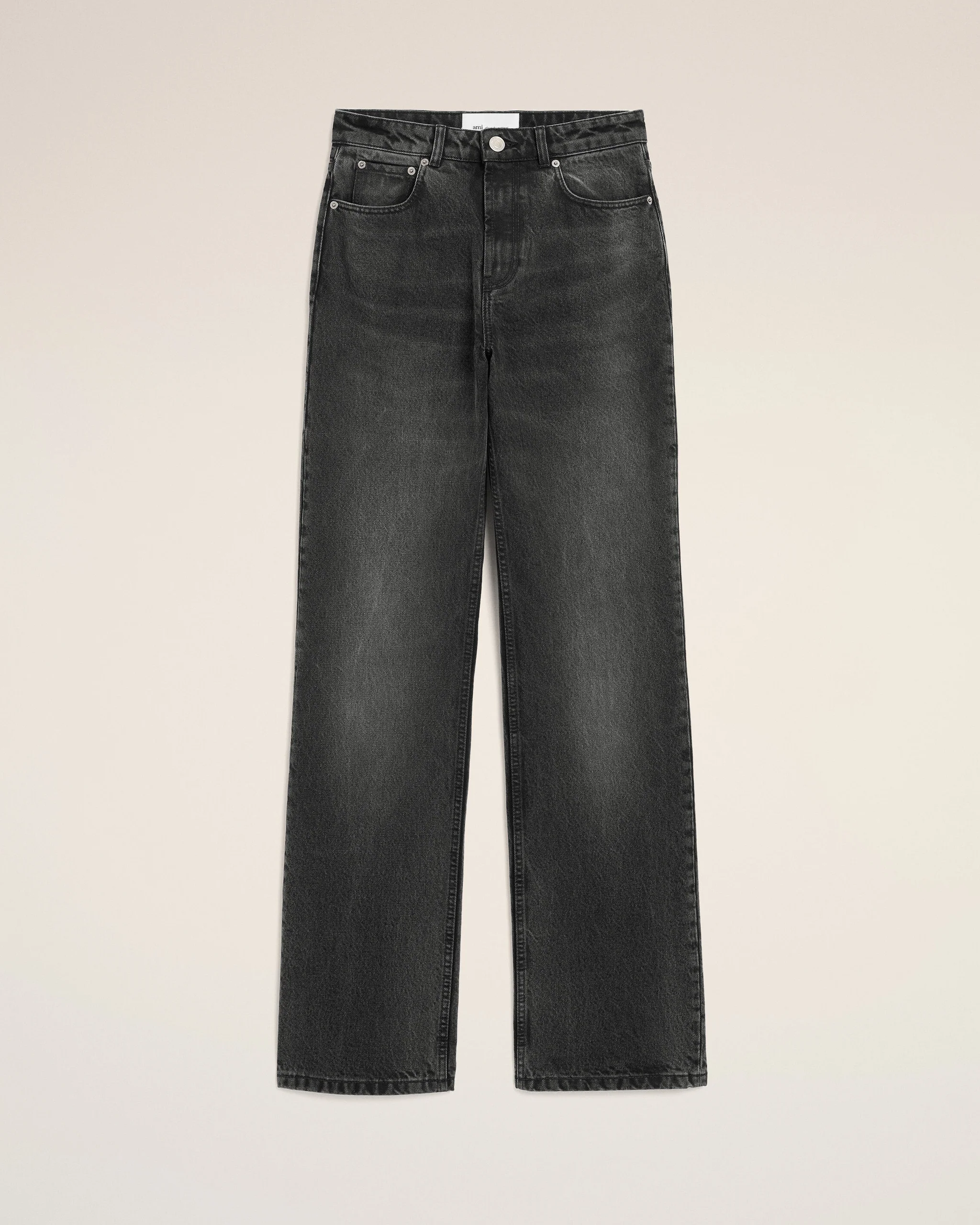 Pair of dark-wash jeans laid flat, front view with pockets and button fly visible on a beige background to showcase the denim pants.