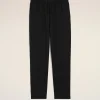 Black jogger pants with an elastic waistband and drawstring laid flat on a beige background, cropped view from the waist down to mid-thighs