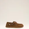 Brown suede boat shoe with white stitching and laces, small 'ami' tag visible on the side, against a light beige backdrop.