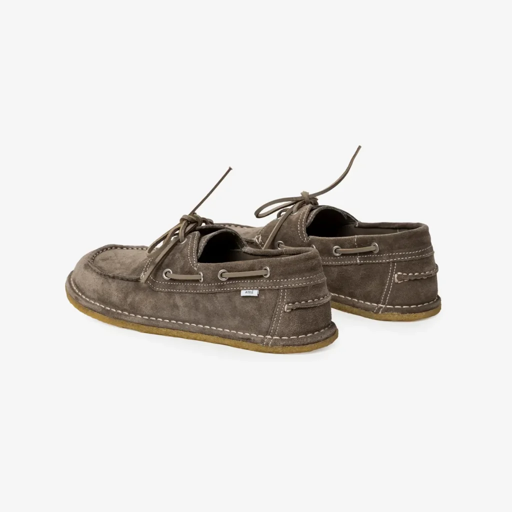 Brown suede boat shoes with white stitching and laces, shown from a side angle on a light background.