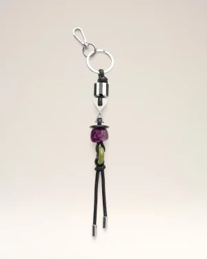 Silver keyring with a black leather cord and colorful beads hanging below (purple and lime).