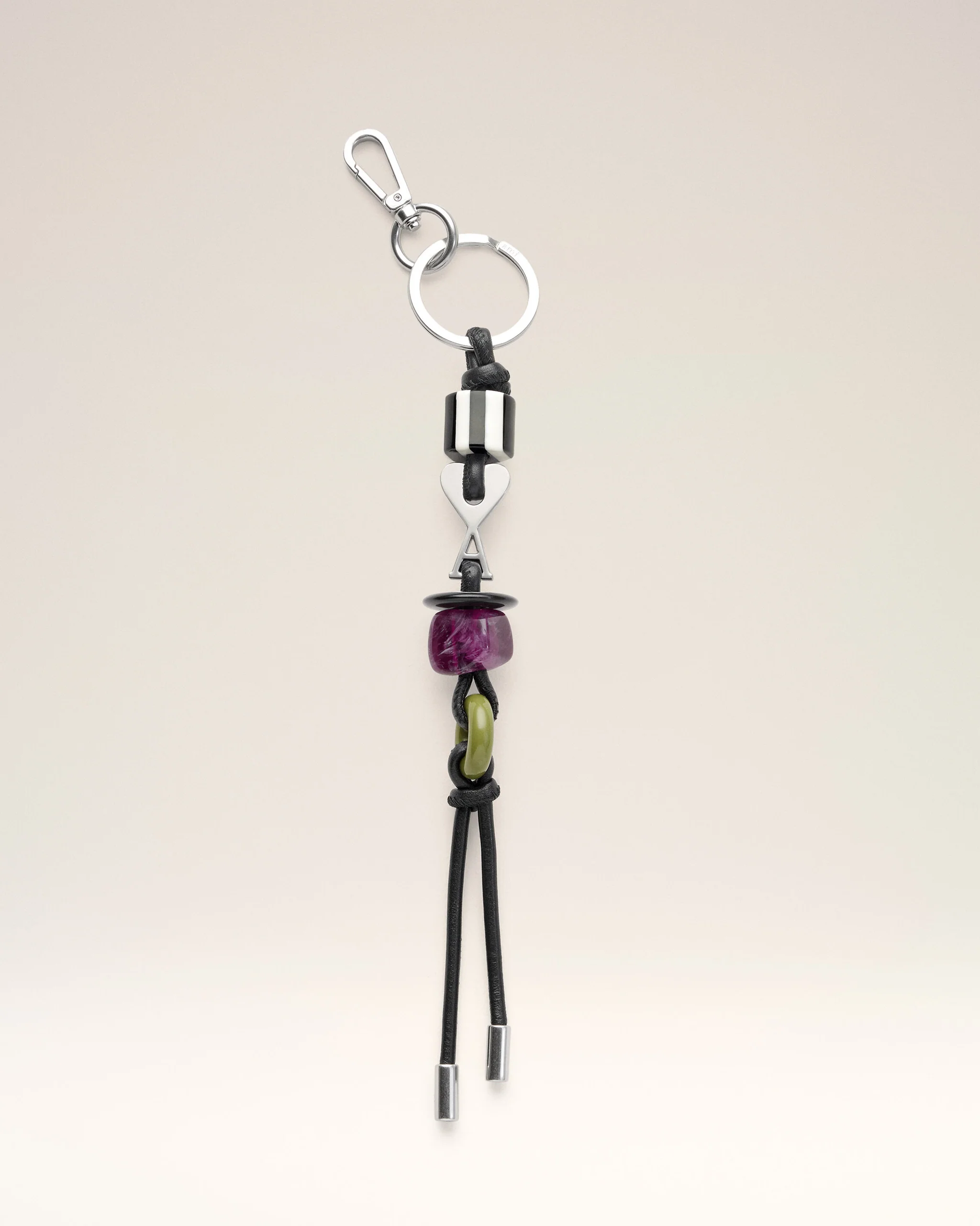 Silver keyring with a black leather cord and colorful beads hanging below (purple and lime).