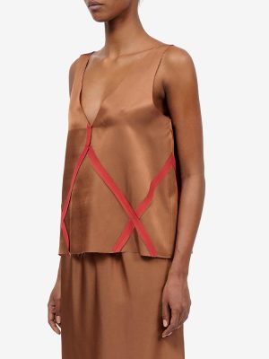 Brown satin sleeveless top with red crisscross straps forming an X on the front, paired with a matching brown skirt.
