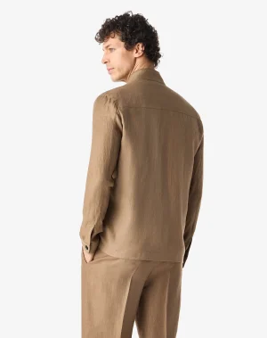 Back view of a man wearing a tan suit jacket and matching trousers against a light background.