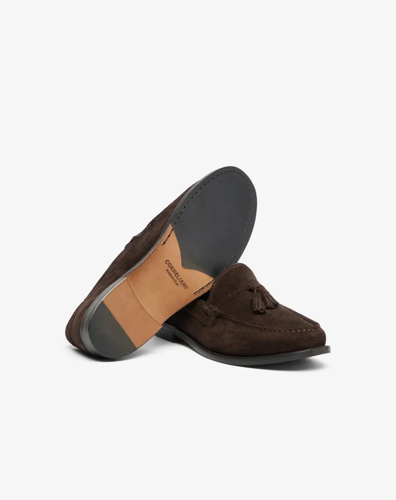 Brown suede tassel loafer with a dark gray toe cap, shown at an angled side view.