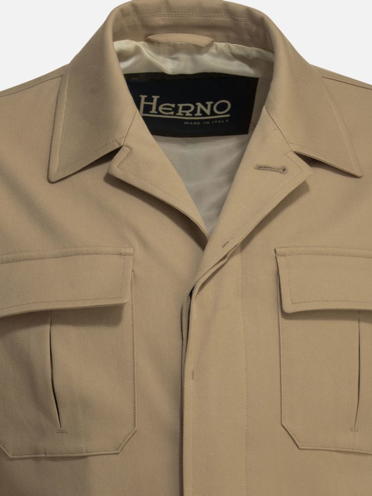 Beige trench coat chest area with large flap pockets and a label reading Herno Made in Italy.