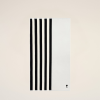Abstract white card with several bold black vertical stripes along the left edge, placed on a pale beige background, with a small X mark bottom-right.