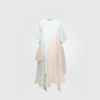 Loose white dress with airy light-blue short sleeves and patchwork polka-dot panels in pink and gray creating an asymmetric hem