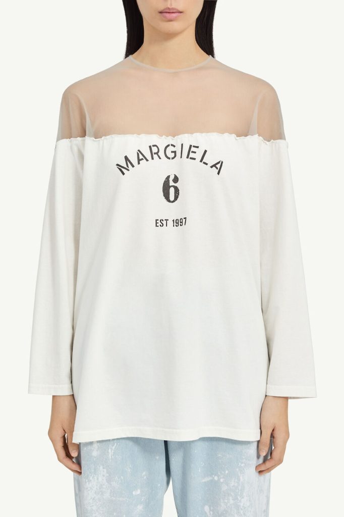 Off-shoulder white top with sheer yoke and printed 'MARGIELA 6 EST 1997' on front.
