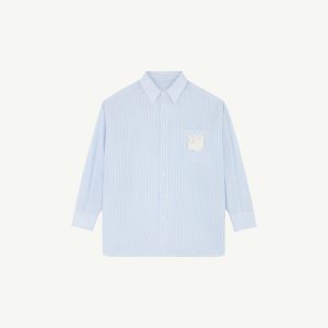 Front view of a light blue striped dress shirt with a pointed collar and visible buttons against a pale background.