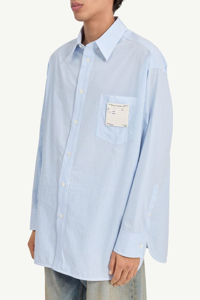 Oversized light blue striped button-down shirt with a chest pocket and a label on the pocket.