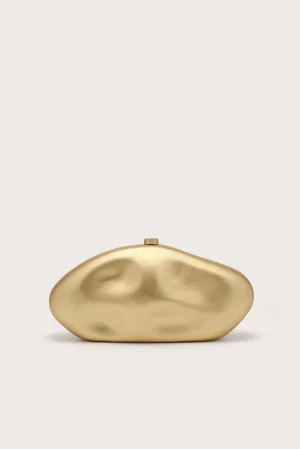 Gold-toned, abstract organic sculpture on a light beige background with soft shadows.