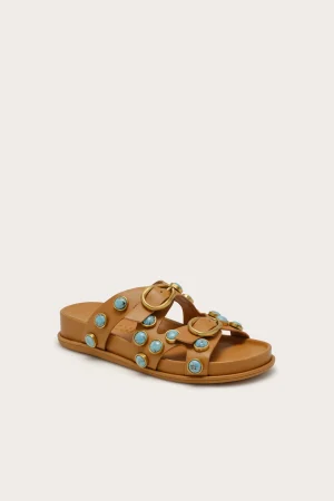 Tan leather sandals with multiple turquoise stone studs and gold rings across the straps, open-toe design.