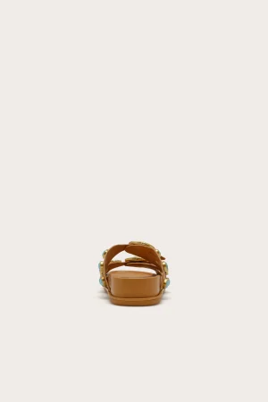 Tan open-toe sandal with straps and turquoise accents, centered on a light background.