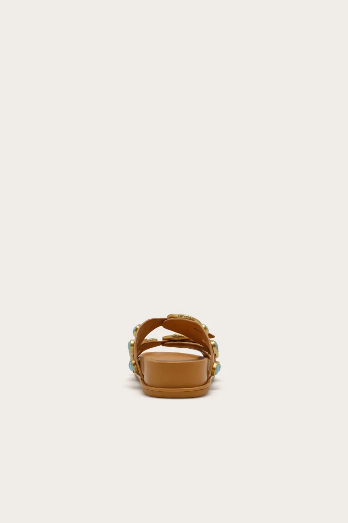 Tan open-toe sandal with straps and turquoise accents, centered on a light background.