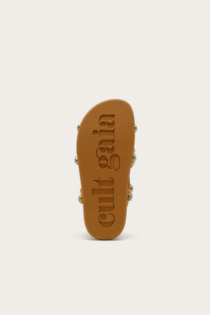 Top-down view of a brown slide sandal with embossed lettering along the footbed in the center
