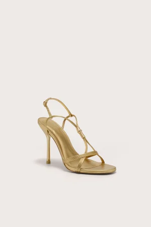 Gold strappy high-heeled sandal with thin ankle strap and stiletto heel, shown from a low front corner view.