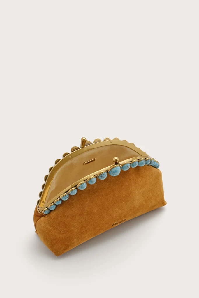 Brown suede clutch with a gold frame and turquoise bead trim, photographed at an angle on a light background