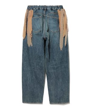 Back view of blue denim pants with an elastic waistband and beige fabric ribbons hanging along the sides, showing two back pockets.