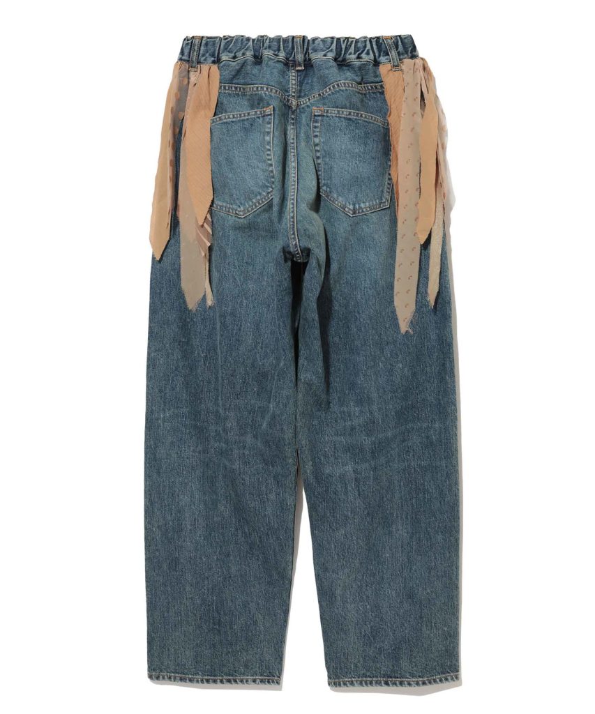 Back view of blue denim pants with an elastic waistband and beige fabric ribbons hanging along the sides, showing two back pockets.