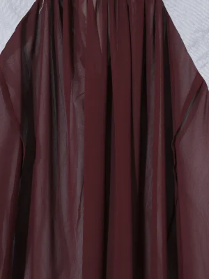 Close-up of burgundy pleated fabric with black vertical stripes.