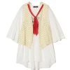 Cream oversized blouse layered with a beige star-pattern vest and a red neck scarf tie.