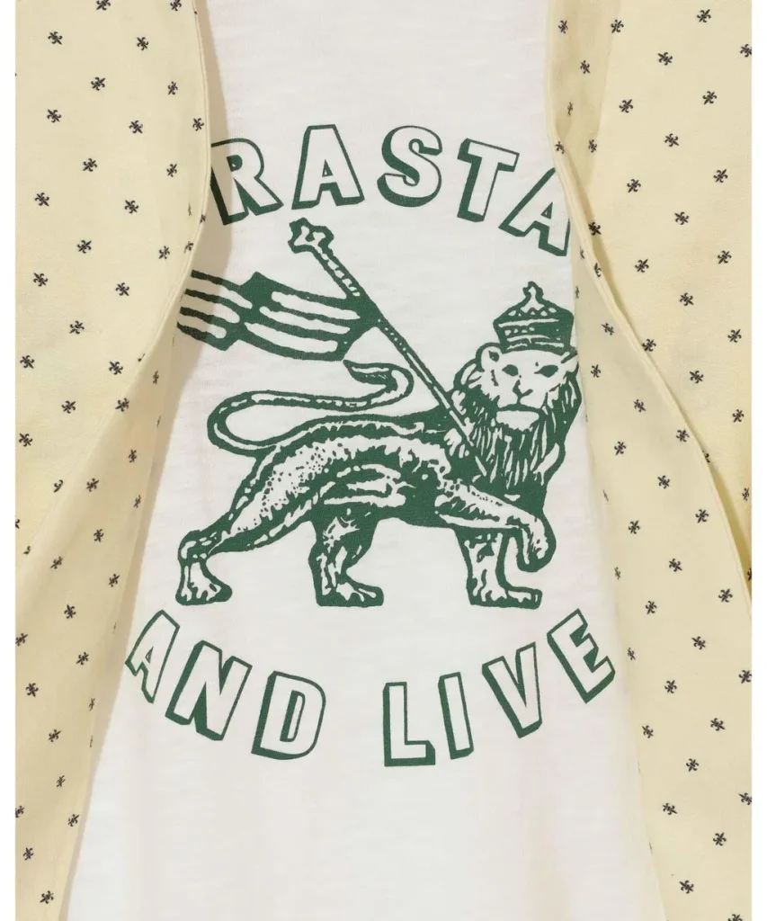 White T-shirt with green graphic of a crowned lion holding a flag; text 'RASTA' above and 'AND LIVE' below.