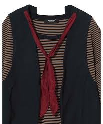 Black sleeveless vest worn over a brown-and-black striped top with a red scarf tied in front.