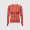 Red long-sleeve top with a repeating black crescent pattern on a mannequin form