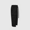 Black tie with a small circular pattern, hanging against a pale gray background (cropped at the bottom).