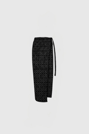 Black tie with a small circular pattern, hanging against a pale gray background (cropped at the bottom).