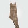 Plaid sleeveless dress with an asymmetrical ruffle hem in tan and brown tones with thin straps.