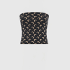 Dark, curved ottoman covered in dark fabric with a repeating beige crescent pattern