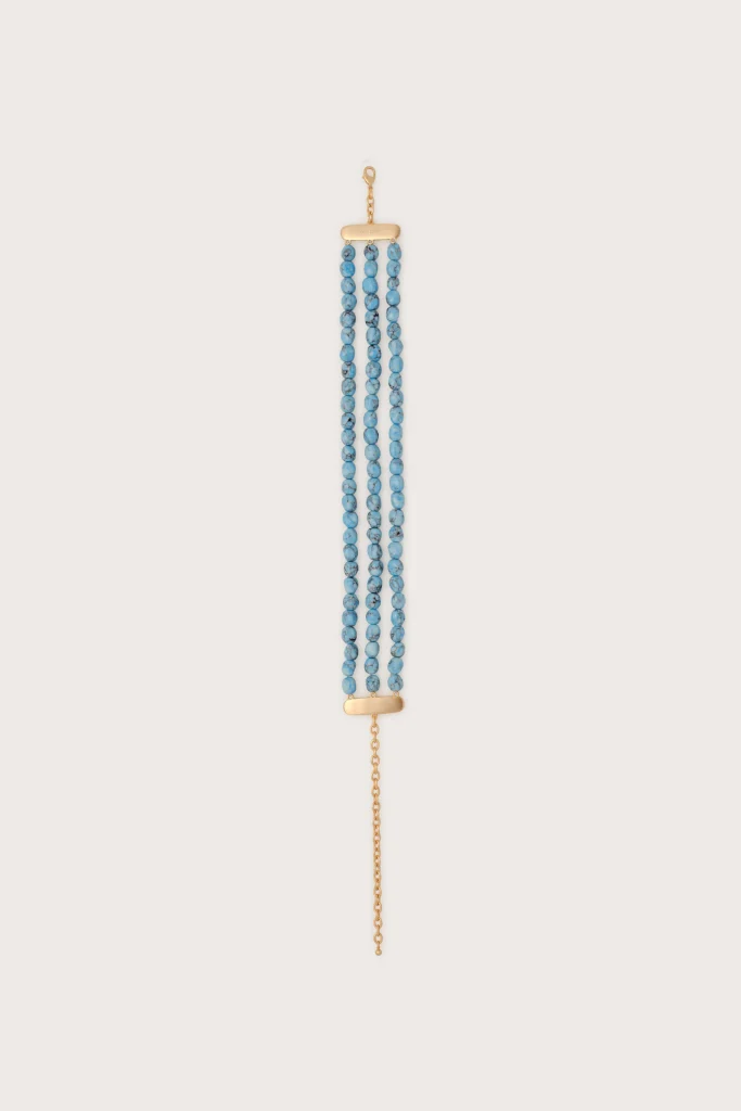 A gold-tone necklace with three strands of small blue beads and a gold clasp at the top and bottom.