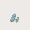 Gold-plated jewelry set with blue turquoise stones arranged as two long oval pieces and a matching band on a pale background