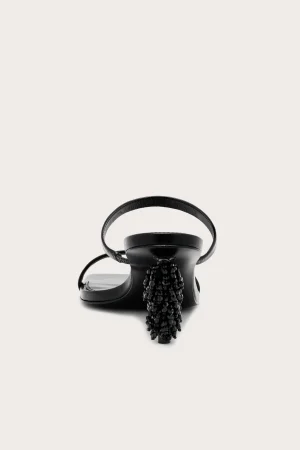 Black strappy sandal with a high beaded heel, pictured against a pale background.