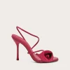 Bright pink high-heeled sandal with thin straps and a decorative knot at the toe area.