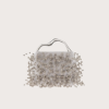 White beaded handbag with a curved metal handle against a pale background.