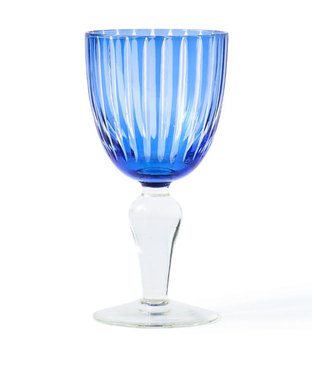 Blue ribbed glass goblet with a clear stem on a white background, photographed front-facing.