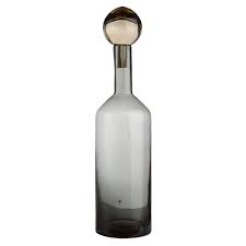 Clear glass bottle with a round glass stopper on a white background.