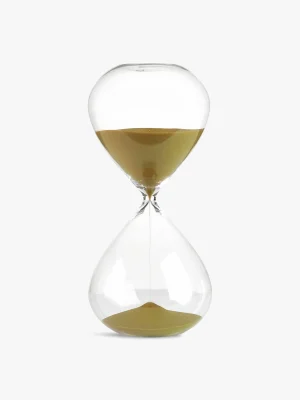 Hourglass with golden sand halfway through, set against a white background (time passing concept).