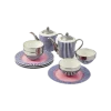 Blue and white striped porcelain tea set with pink accents, including two teapots, two teacups, and matching saucers on a white surface.